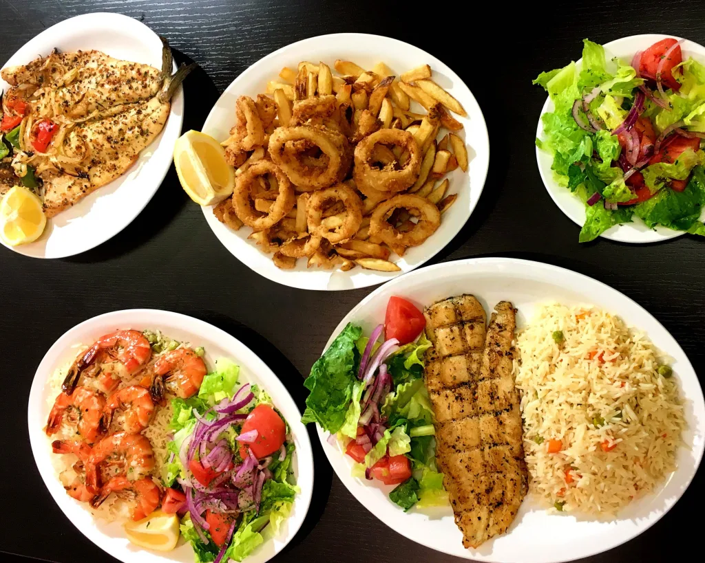 Multiple sea food dishes on a table ready to eat.